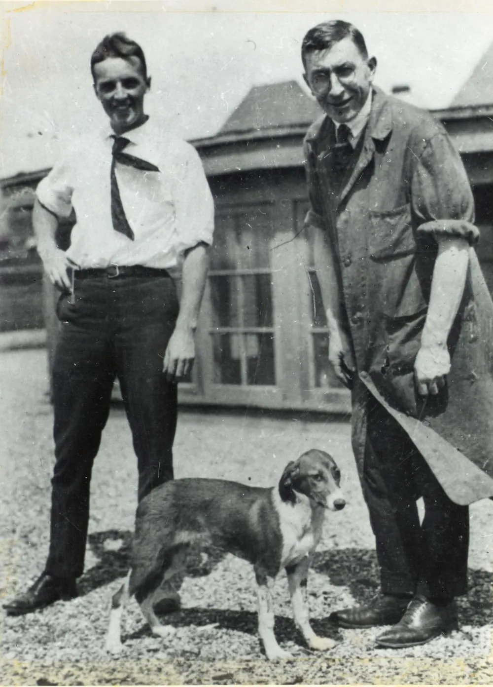 Frederick Banting y Charles Best de pie junto a un perro en la azotea del edificio de medicina de la Universidad de Toronto, 1921
